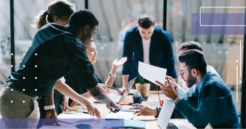 People sitting at a desk and discussing work at their office